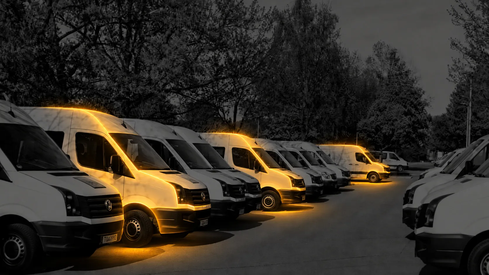 Three separated service vehicles glow amber among an otherwise monochrome commercial fleet.